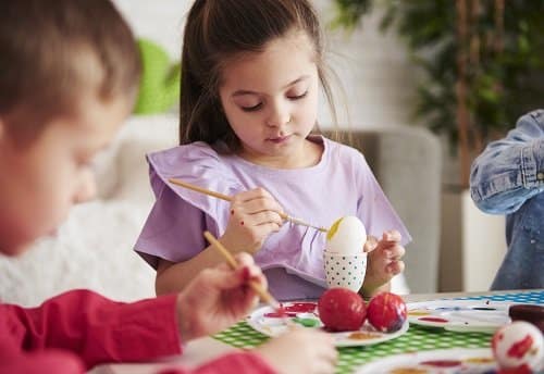 focused girl painting easter eggs