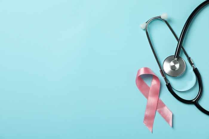 pink awareness ribbon and stethoscope on blue background