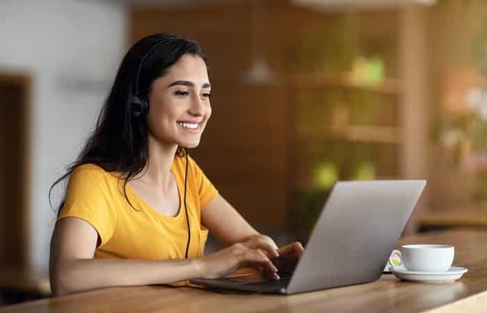 joyful girl student studying online at cafe