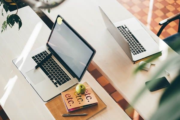 laptop on table in meeting room of office workspace.