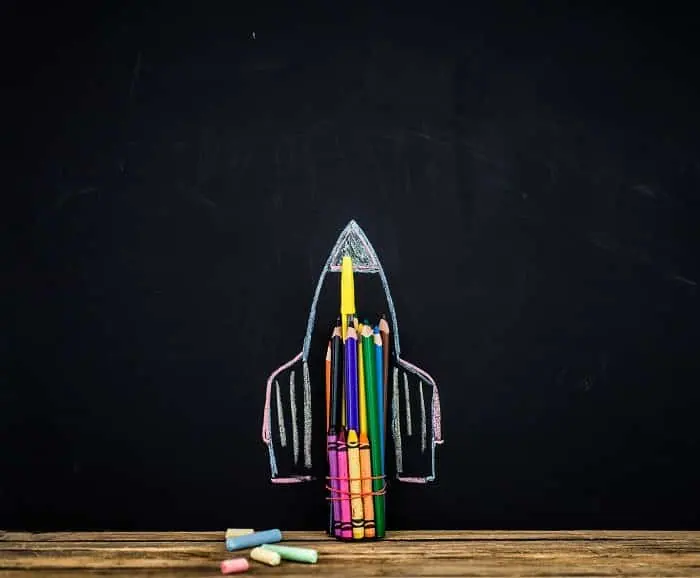 back to school black background the missile made with pencils, drawing crayons books