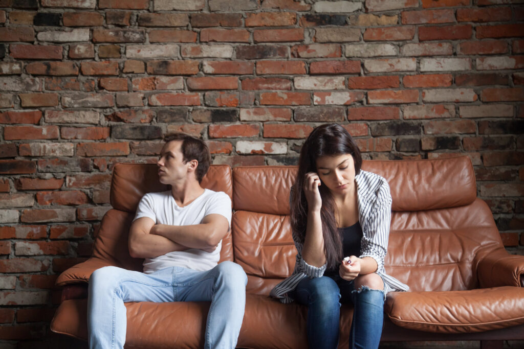 Sexología Clínica: Comunicación efectiva en parejas como clave de éxito terapéutico frustrated upset couple after quarrel sitting sofa home