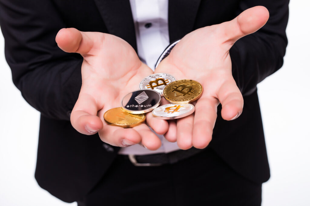 Criptomonedas y Blockchain: Impacto en la Contabilidad y Auditoría Financiera man holds different crypto coins in his hands isolated on white