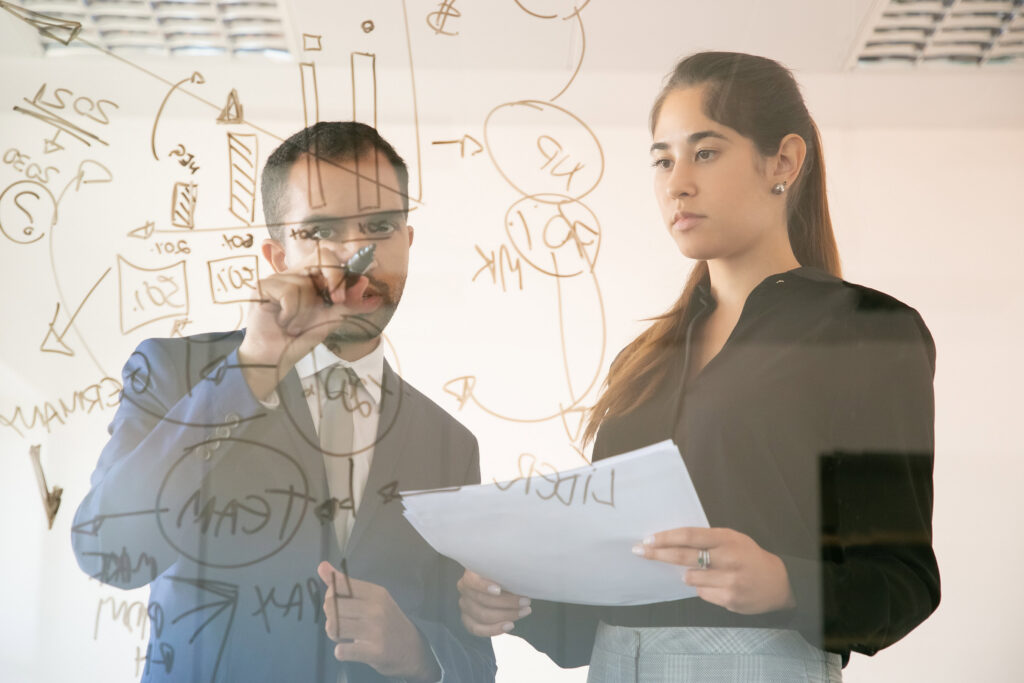 content african american manager writing chart on glass board