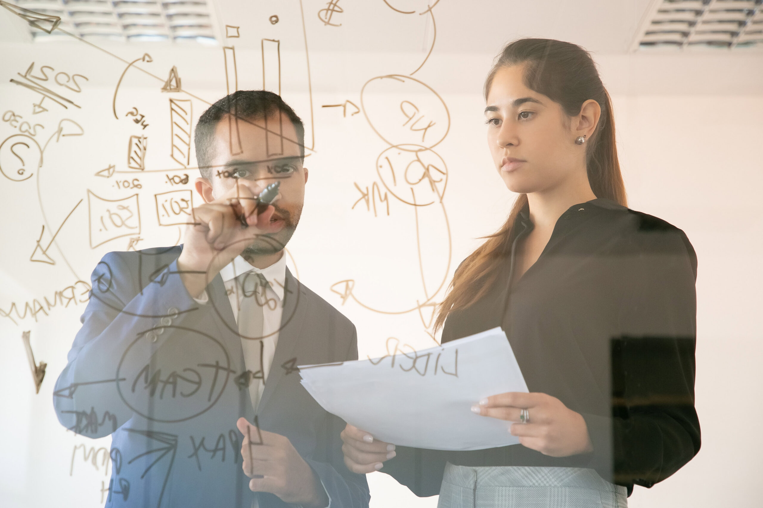 content african american manager writing chart on glass board